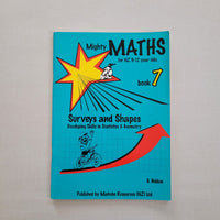 Book titled 'Mighty Maths Book 7' on a gray background