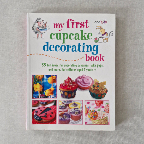Book titled 'My First Cupcake Decorating Book' on a gray background