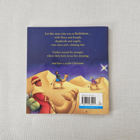 Back book cover with nativity scene illustration and text on a textured surface
