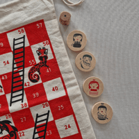 Board game pieces with a red and white board featuring numbers and black illustrations.