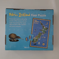 New Zealand floor puzzle box in light blue packaging, showing the product title, a kiwi bird illustration, and a sample of the puzzle piece layout on the front.