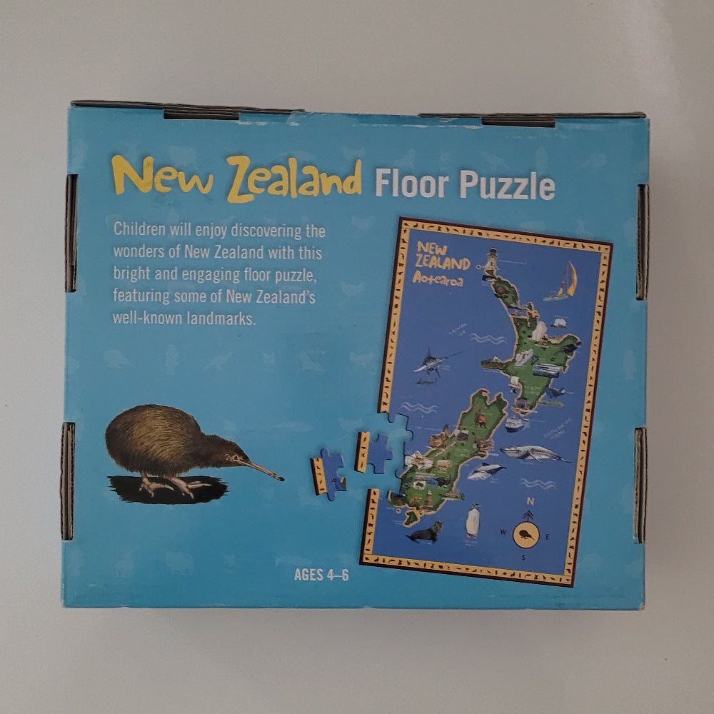 New Zealand floor puzzle box in light blue packaging, showing the product title, a kiwi bird illustration, and a sample of the puzzle piece layout on the front.