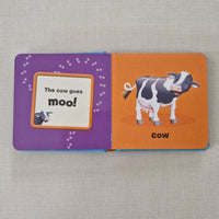 Children's book with a cow illustration on an orange and purple background