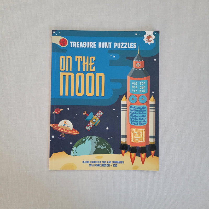 Book titled 'On the Moon' with space-themed illustrations on a gray background