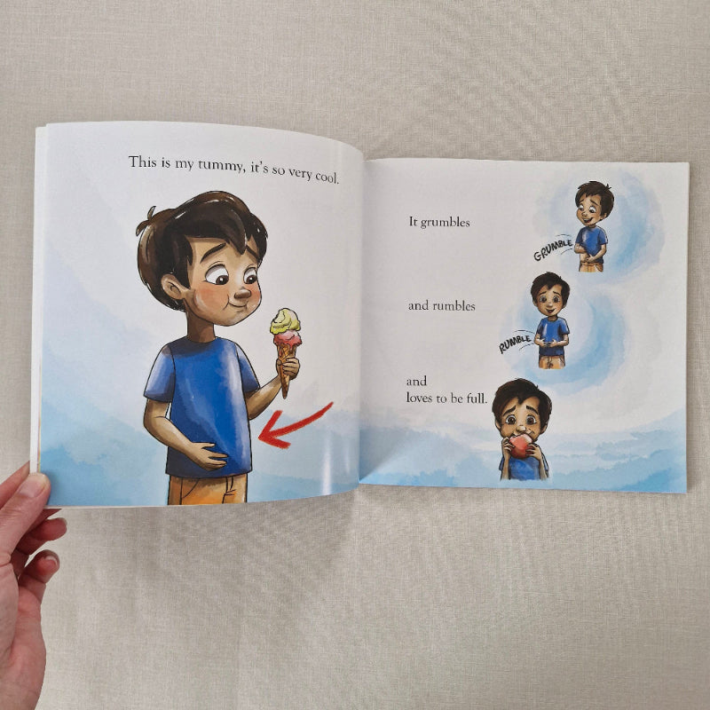 Open book showing illustrations of a child with an ice cream and text about tummy feelings.