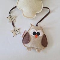 Baby mobile with owl and star designs on a light background