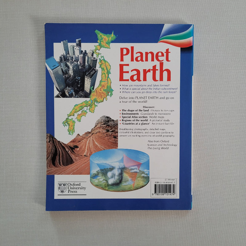 Book titled 'Planet Earth' with images of landscapes and scientific equipment on a gray background