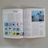 Open book with illustrations and text about wind on a plain background