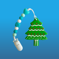 Christmas tree-shaped teether on a blue pacifier clip with beads on a blue background