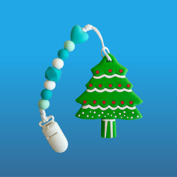 Christmas tree-shaped teether on a blue pacifier clip with beads on a blue background