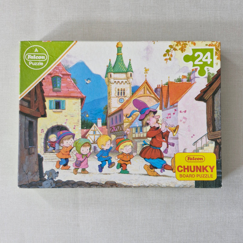 Jigsaw puzzle box with colorful illustration on a grey surface