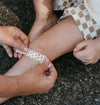 Person applying a lion bandage to a child's knee on a dark surface