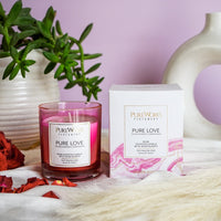 Pure Works energy candle sitting on a table with box packaging 
