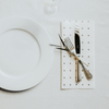 White plate with silverware on a reusable bamboo towel as a napkin
