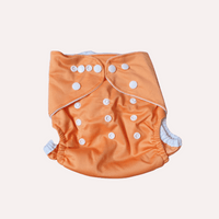 Orange reusable cloth nappy with white buttons on a light grey background