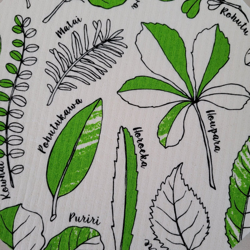 Pattern of green leaves and plant illustrations that are on Tayna Wolfkamp's round dishcloth