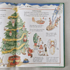 Open book with Christmas-themed illustrations and text on a textured surface