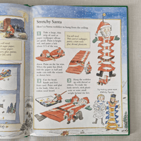 Open book with a craft project for Stretchy Santa on a textured surface