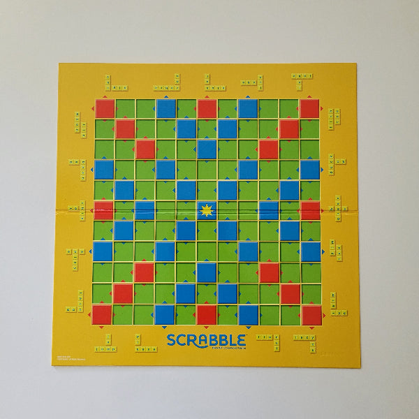 Scrabble board game board with letter tiles on a yellow background
