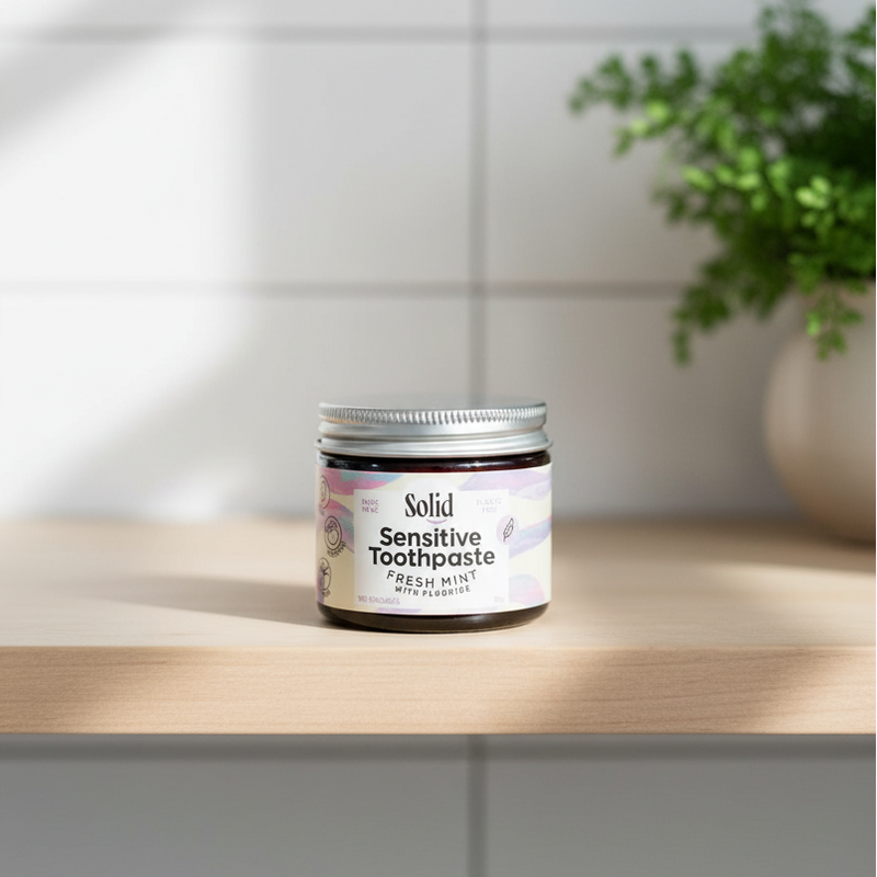 Jar of Solid Sensitive Toothpaste sitting on a wooden shelf