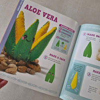 Aloe vera craft kit with instructions and a completed aloe vera plant model on a grey surface.