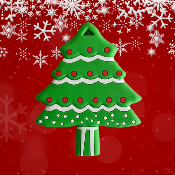 A green Christmas tree-shaped teething toy with white and red accents, presented against a red background with white snowflakes.