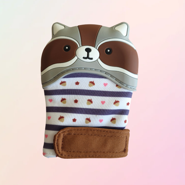A silicone teething mitt designed to resemble a brown raccoon with a striped pattern and a velcro strap.