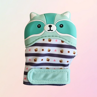 A green silicone teething mitt designed to resemble a raccoon with a striped pattern and a velcro strap.