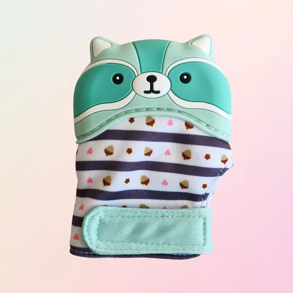 A green silicone teething mitt designed to resemble a raccoon with a striped pattern and a velcro strap.
