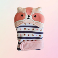 A pink silicone teething mitt designed to resemble a raccoon with a striped pattern and a velcro strap.