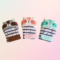 Three coloured teething mitts in the shape of a racoon on a white background