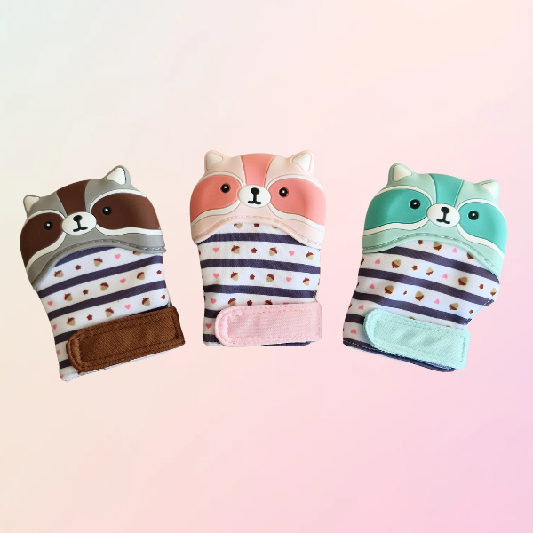 Three coloured teething mitts in the shape of a racoon on a white background