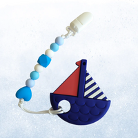 Silicone teething toy in the shape of a boat with a pacifier clip attached