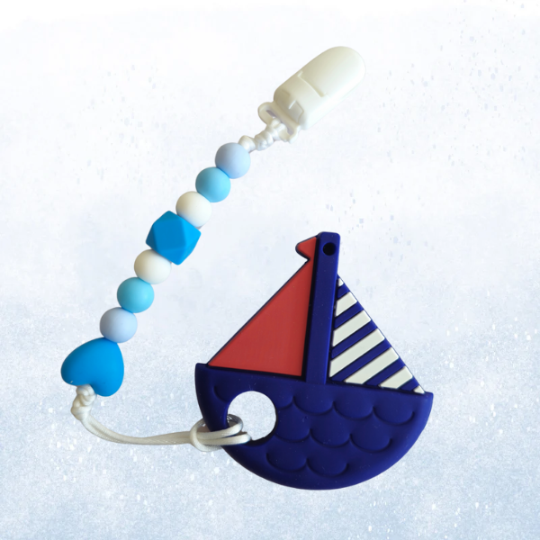 Silicone teething toy in the shape of a boat with a pacifier clip attached