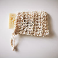 Soap saver bag with bar of soap sticking out of the top