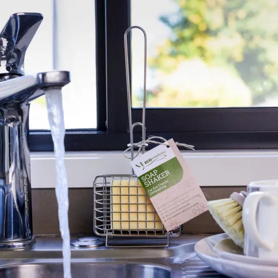 Soap shaper in a kitchen sink with water running and a window in the background