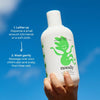 Hand holding a bottle of noody baby wash with usage instructions on a blue background