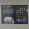 Open book about the Moon with images and text on a grey background