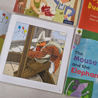 Collection of children's books with colourful covers on a light grey surface