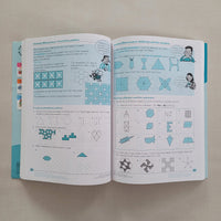 Open book with geometric shape patterns on a beige surface