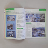 Open book with art instruction pages on a plain background