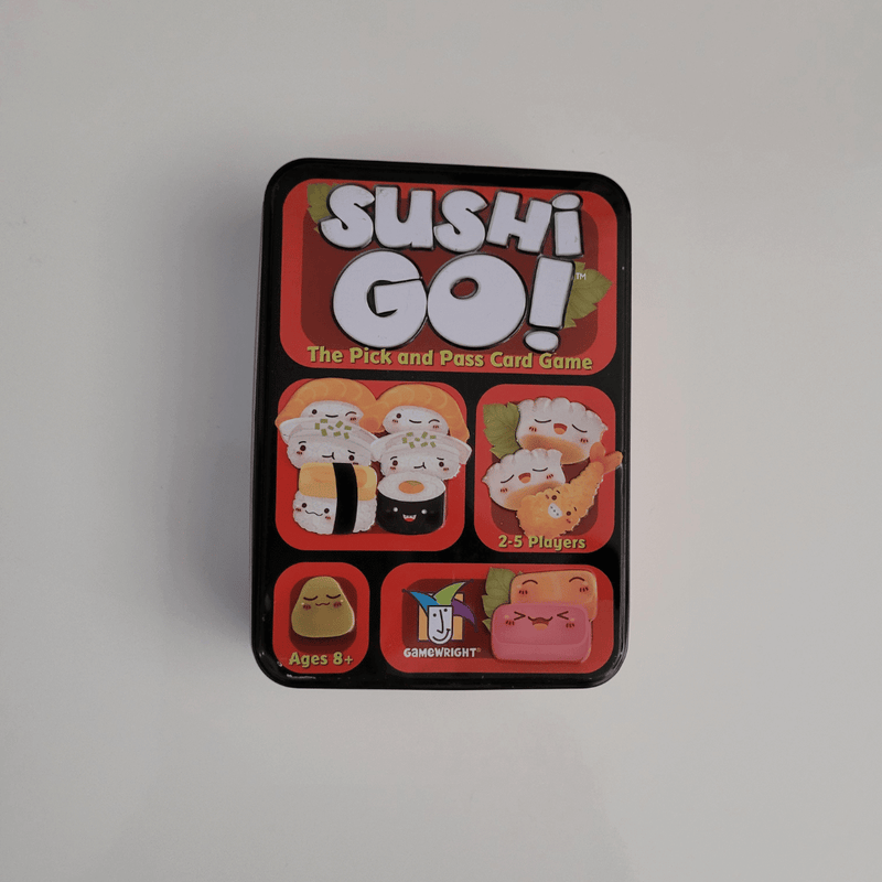 Sushi Go! card game tin on a light grey background