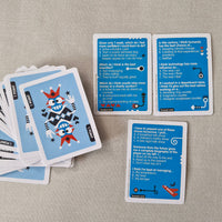 Card game with blue question cards and a stack of cards on a textured surface