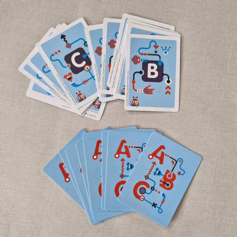 Stacks of blue cards with red and black designs on a beige fabric background