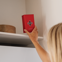 Person reaching for a red box labeled 'PATCH' on a shelf.