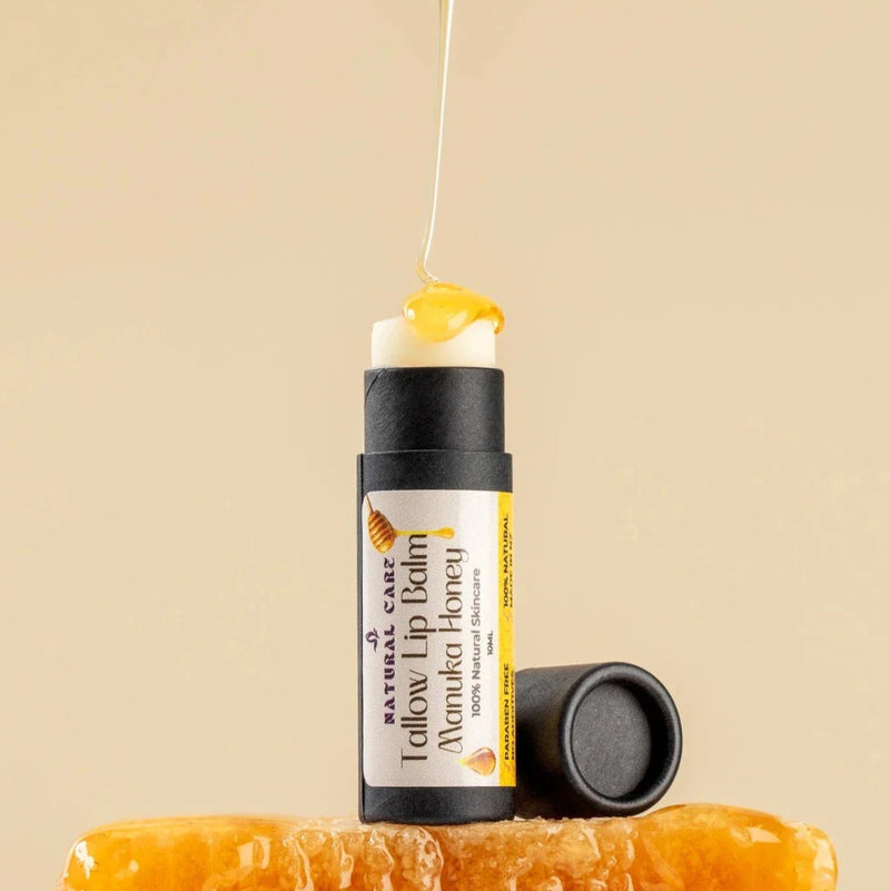 Natural lip balm with tallow and manuka honey. Honey is being dripped onto it, set against a beige background.