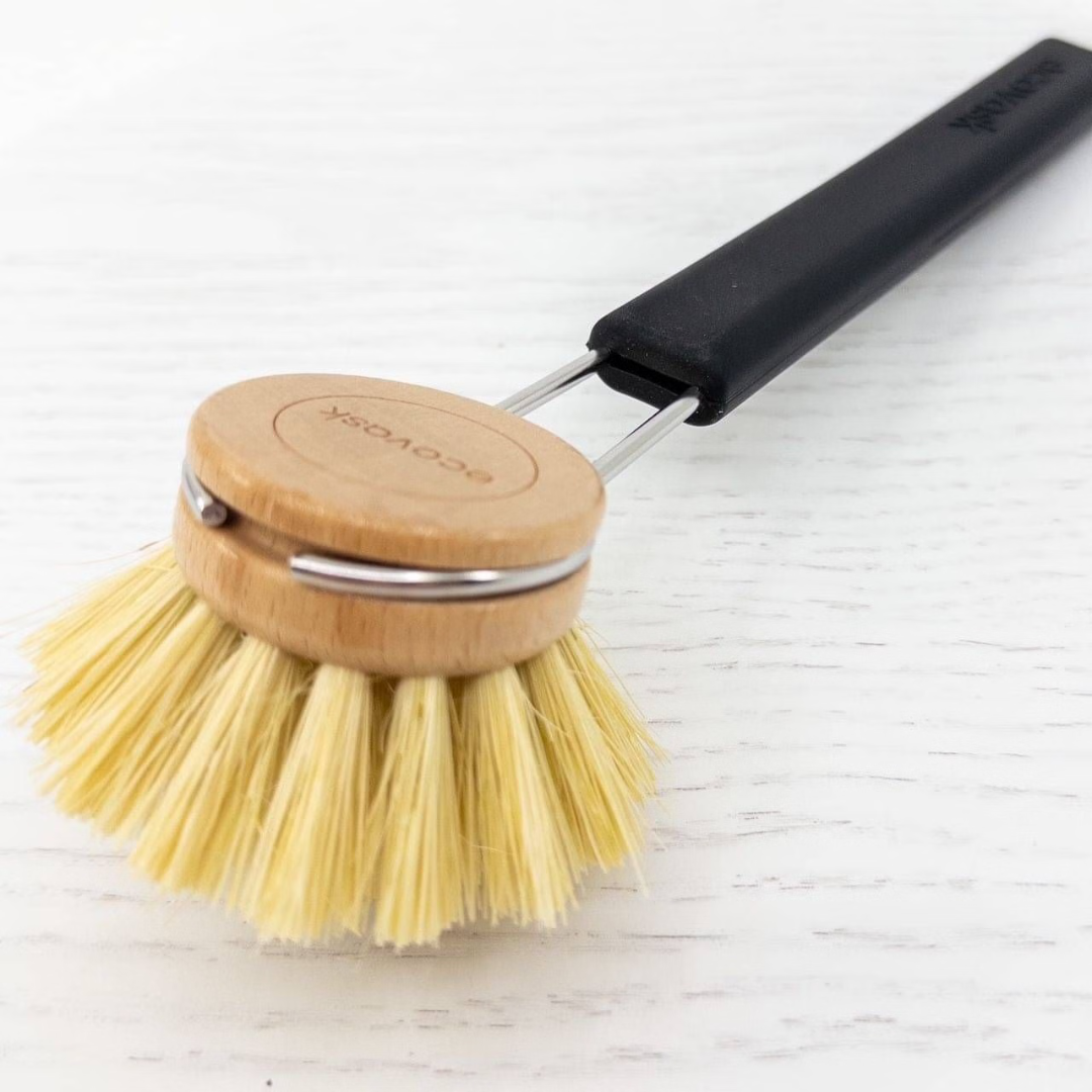 Dishwashing brush with black silicone handle and tampico bristles on a white background