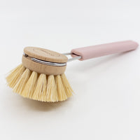 Wooden tampico dish brush head with pink silicone handle on white background