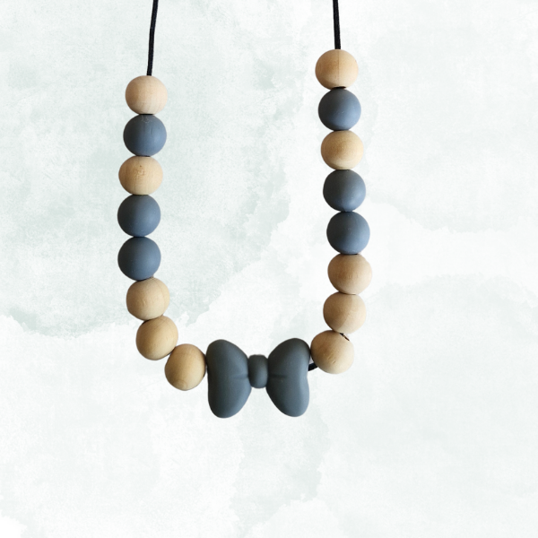 Teething necklace with blue and beige beads with a grey bow on a white background