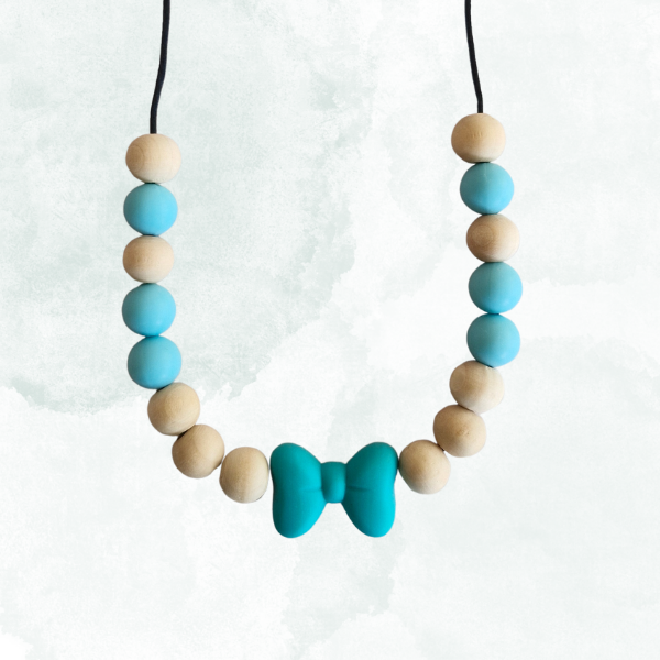 Teething necklace with blue and beige beads and a bow-shaped pendant on a white background